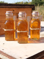 1 pound pure local honey in 1lb muth jar sitting on wooden beehive.